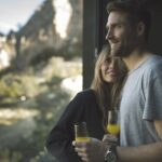 Pareja disfrutando de una copa mientras contemplan el paisaje natural desde la habitación en VIVOOD
