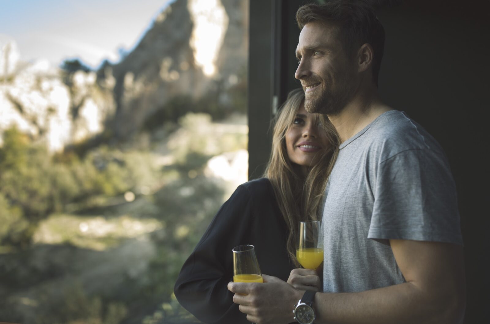 Pareja disfrutando de una copa mientras contemplan el paisaje natural desde la habitación en VIVOOD